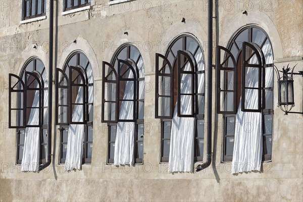 Window front with white curtains in historical building
