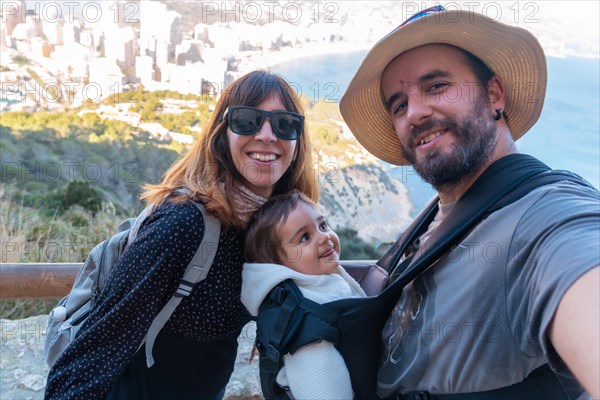 A family looking at the city of Calpe from the path of the Penon de Ifach Natural Park