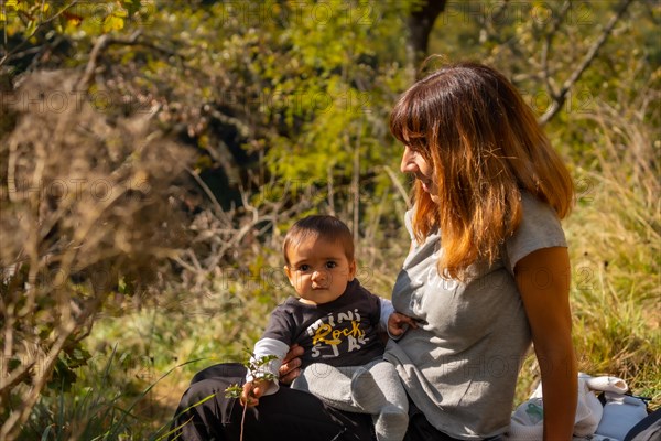 A mother with her baby in the forest near the Holtzarte suspension bridge