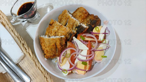 Authentic traditional Filipino breakfast of fried bangus or milkfish with tomato and salted duck egg salad from Philippines