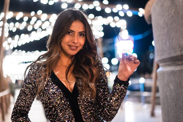 Winter lifestyle at Christmas. Brunette Caucasian girl in a fashionable dress with sequins