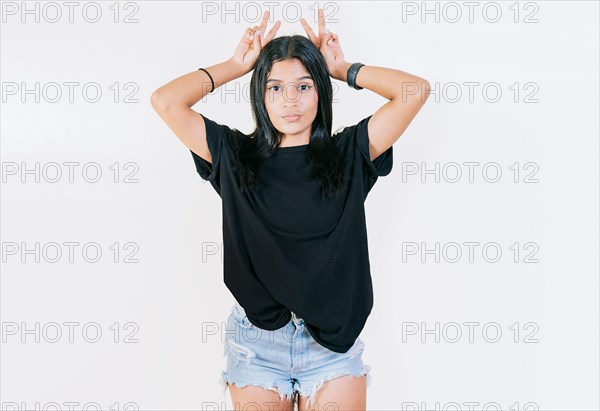 Young girl making horns gesture with their fingers