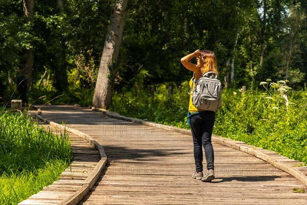 A young woman trekking on the footpath along a footbridge between La Garette and Coulon