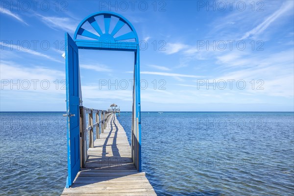 A blue door on the beach of Sandy Bay on the Roatan Island of the Caribbean Sea. Honduras