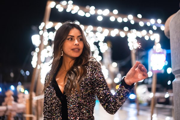 Winter lifestyle at Christmas. Brunette Caucasian girl in a fashionable dress with sequins