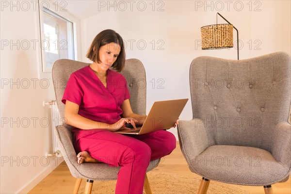 Frontal view of a serious female nutritionist doctor attending clients online from home