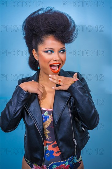 A closeup portrait of a fashion attractive rocker style woman with bright makeup wearing a leather jacket