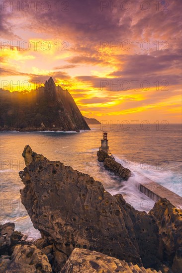 Long exposure in the orange sunset at the lighthouse in the municipality of Pasajes San Juan in Gipuzkoa. Basque Country