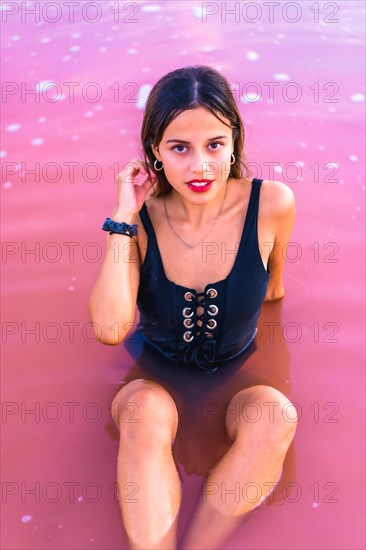 Posing of a young brunette Caucasian on summer vacation in the pink lagoon of Torrevieja