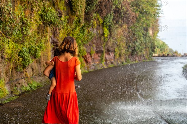 A mother with her son in a red dress at Anjos Waterfall