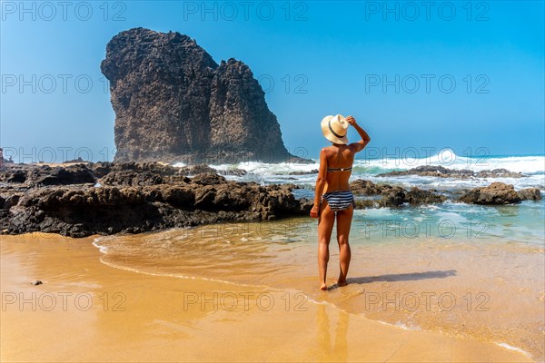 A young tourist with a hat in the Roque del Moro of the Cofete beach of the Jandia natural park