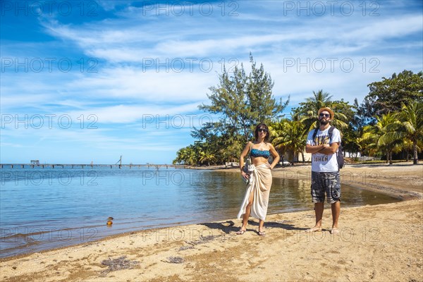 Two young men on the beach of Sandy Bay on Roatan Island. Honduras