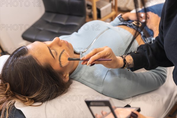 Make up artist applying mascara to a client in a beauty salon