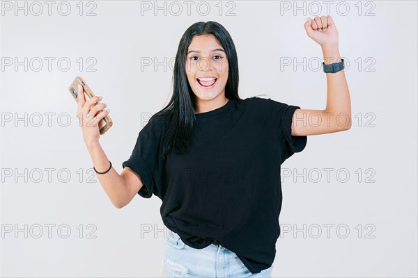 Happy people holding smartphone and celebrating. Winner happy young girl holding cell phone. Happy teen girl celebrating with phone isolated