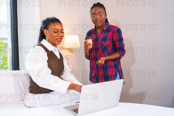 Young businesswomen of black ethnicity. Teleworking with a laptop from a hotel room