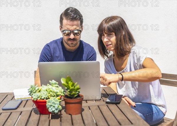 A couple confined at home making a video call with some friends with the computer