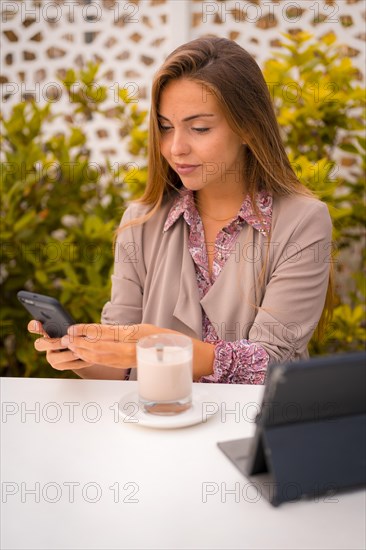 Female executive and businesswoman having breakfast in a cafe decaf and looking at email