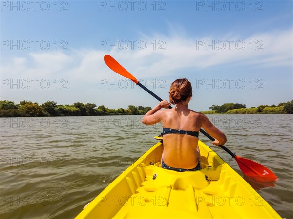 A young woman in the canoe canoeing in a natural park in Catalonia