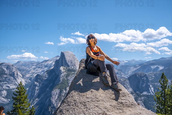 A young woman in pink and black at the Glacier point on the Half Dome wall. Yosemite National Park