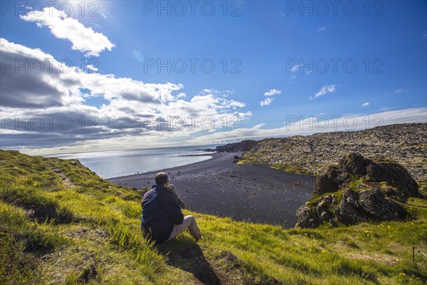 A boy in the beautiful black stone beach from above the Snaefellsnes coast. Iceland