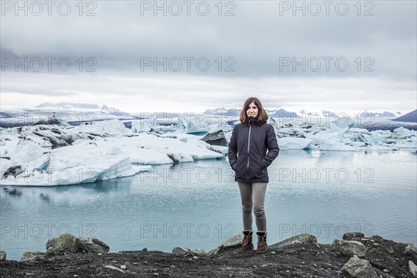 A cwoman with a backpack looking at the Jokulsarlon Ice Lake in the golden circle