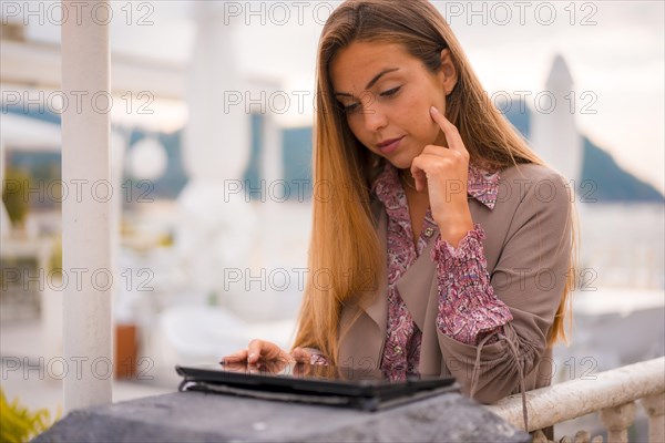 A female executive and businesswoman on break from work reading emails on a tablet