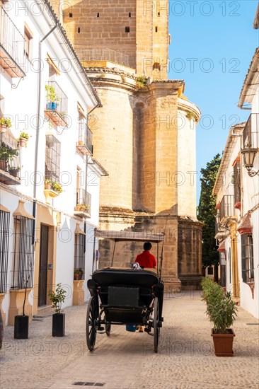 Carriage with tourists next to the Church of Santa Maria la Mayor in the historic center of Ronda