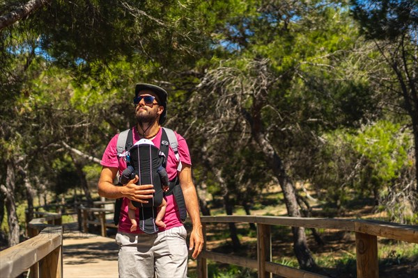 A young father on the path to Playa Moncayo on the Mediterranean Sea in Guardamar del Segura next to Torrevieja