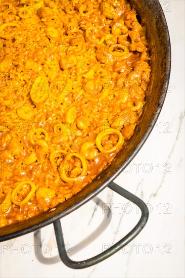 Details of the Valencian paella made on wood and vegetable embers. Traditional Spanish Mediterranean food of fish and seafood