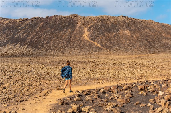 A young woman on the trail to the Crater of the Calderon Hondo volcano near Corralejo