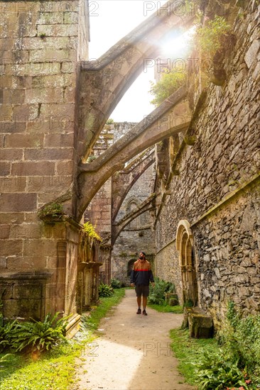 A young man visiting the interior gardens of the Abbaye de Beauport in the village of Paimpol