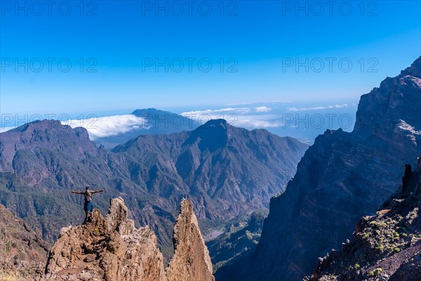 A young man after finishing the trek at the top of the volcano of Caldera de Taburiente near Roque de los Muchachos looking at the incredible landscape