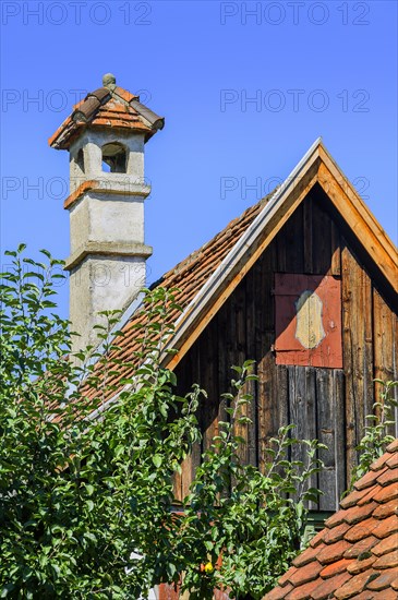 Pointed gable with wooden facade and brick chimney in the Farm Museum