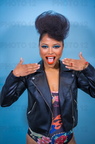 A closeup portrait of a fashion attractive rocker style woman with bright makeup wearing a leather jacket