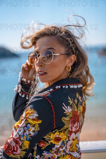 Fashion portrait of a blonde woman on a terrace enjoying summer vacations