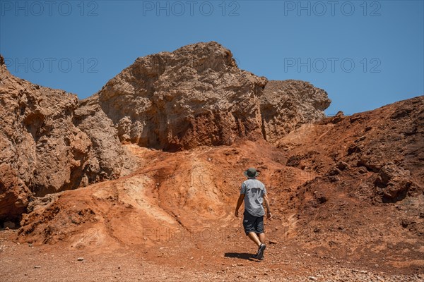 A man tourists walking white salt of Badwater Basin alerted by extreme heat