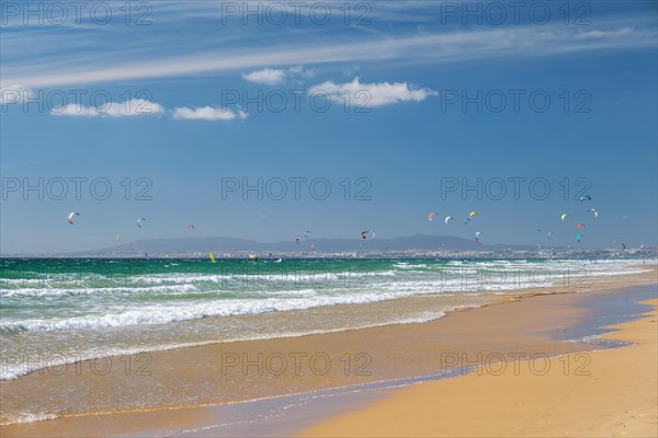 Kiteboarding kitesurfing kiteboarder kitesurfer kites on the Atlantic ocean beach at Fonte da Telha beach