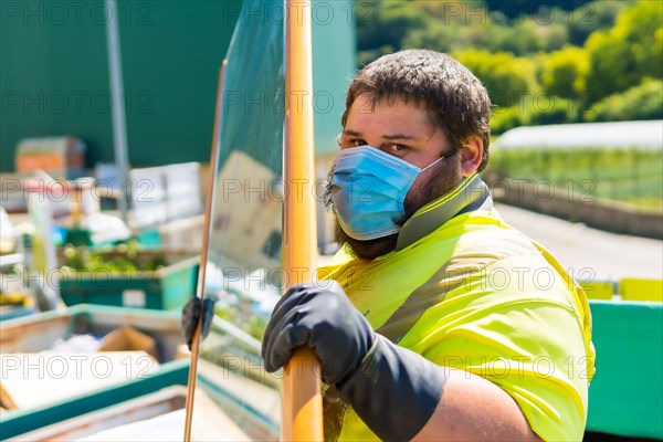 Worker in a recycling factory or clean point and garbage with a face mask and with security protections