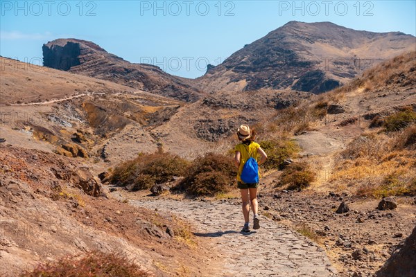 Young woman tourist on a trekking trail in Ponta de Sao Lourenco in summer