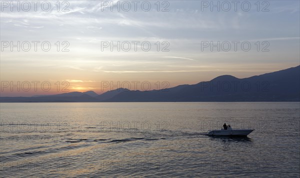 Single motorboat sailing on Lake Garda at Torri del Benaco