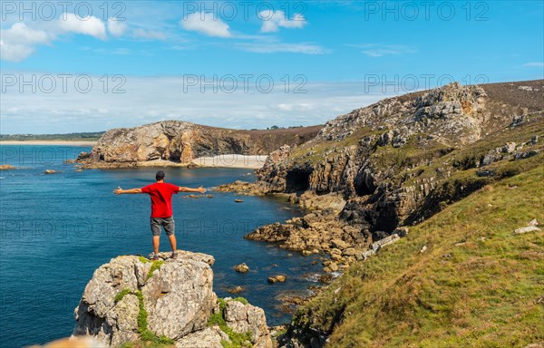 A young man in a red shirt on the coast enjoying the summer at Le Chateau de Dinan on the Crozon peninsula in French Brittany
