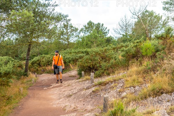 A young man on the footpath in the Broceliande forest
