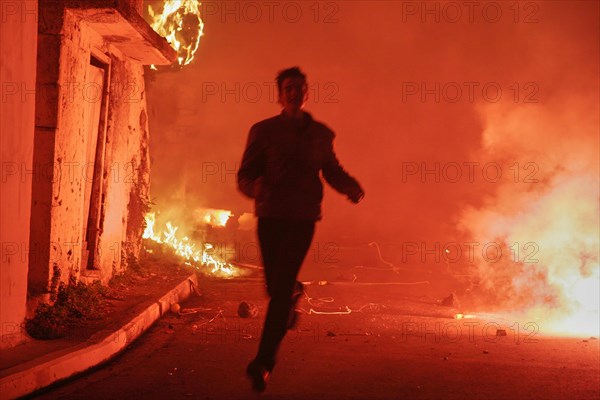 Young man runs through pyrotechnics
