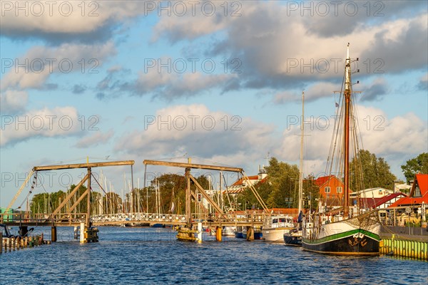 Historic Wieck wooden bascule bridge over the river Ryck and sailing ships in the harbour