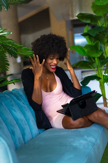 Young entrepreneur of black race and afro hair making a video call with a tablet