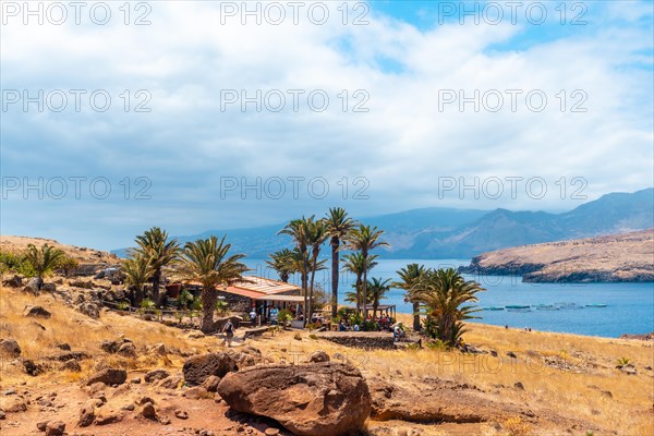 House and bar at the end of the path of Ponta de Sao Lourenco with palm trees in summer