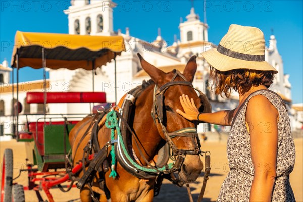 A tourist caressing horses in the El Rocio sanctuary at the Rocio festival