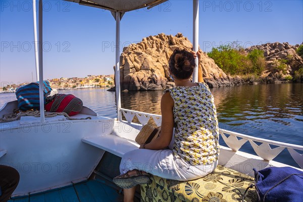 A young woman traveling by boat on the River Nile to the Philae temple dedicated to Isis