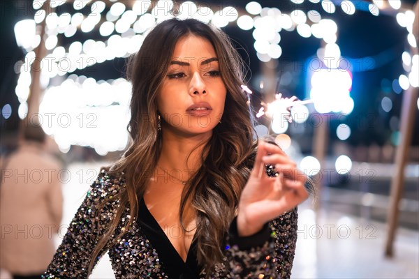 Winter lifestyle at Christmas. Brunette Caucasian girl in a fashionable dress with sequins