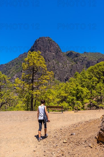 A young woman walking along the La Cumbrecita trail on the island of La Palma next to the Caldera de Taburiente